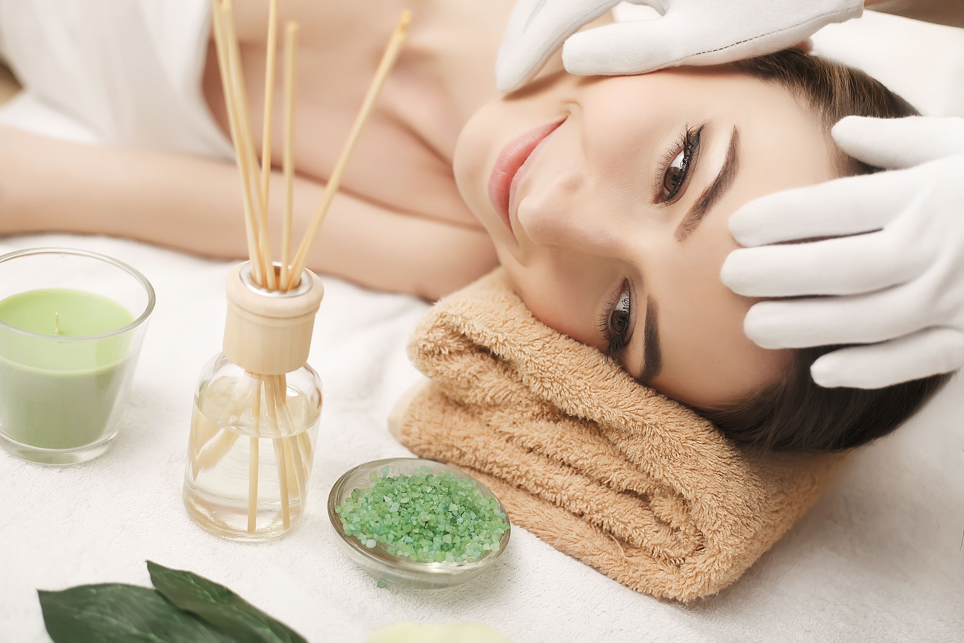 Spa. Massagem facial. Cuidados com a pele e o corpo dos Spa. Close-up da mulher nova que começ o tratamento da massagem dos termas no salão de beleza dos termas. Tratamento de beleza facial.