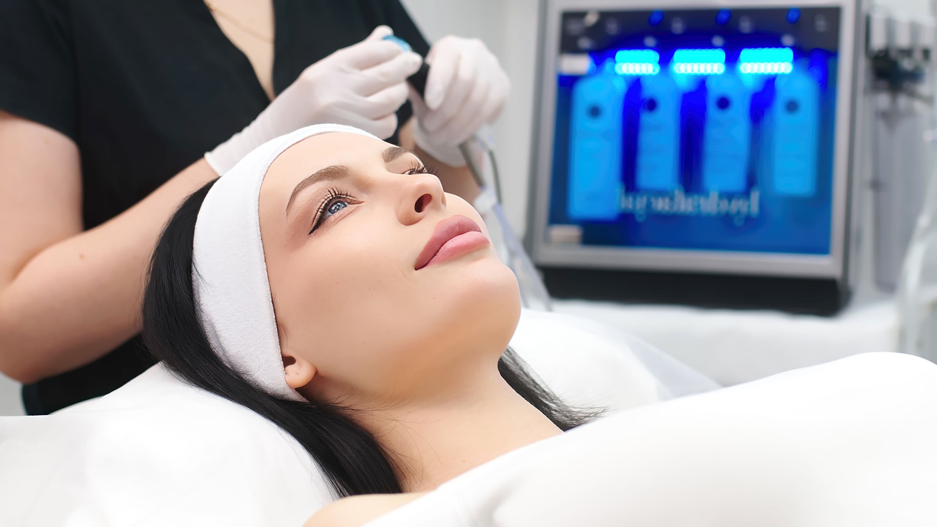 Um cosmetologista prepara um dispositivo para a limpeza facial moderna. Tecnologias modernas de cosmetologia.
