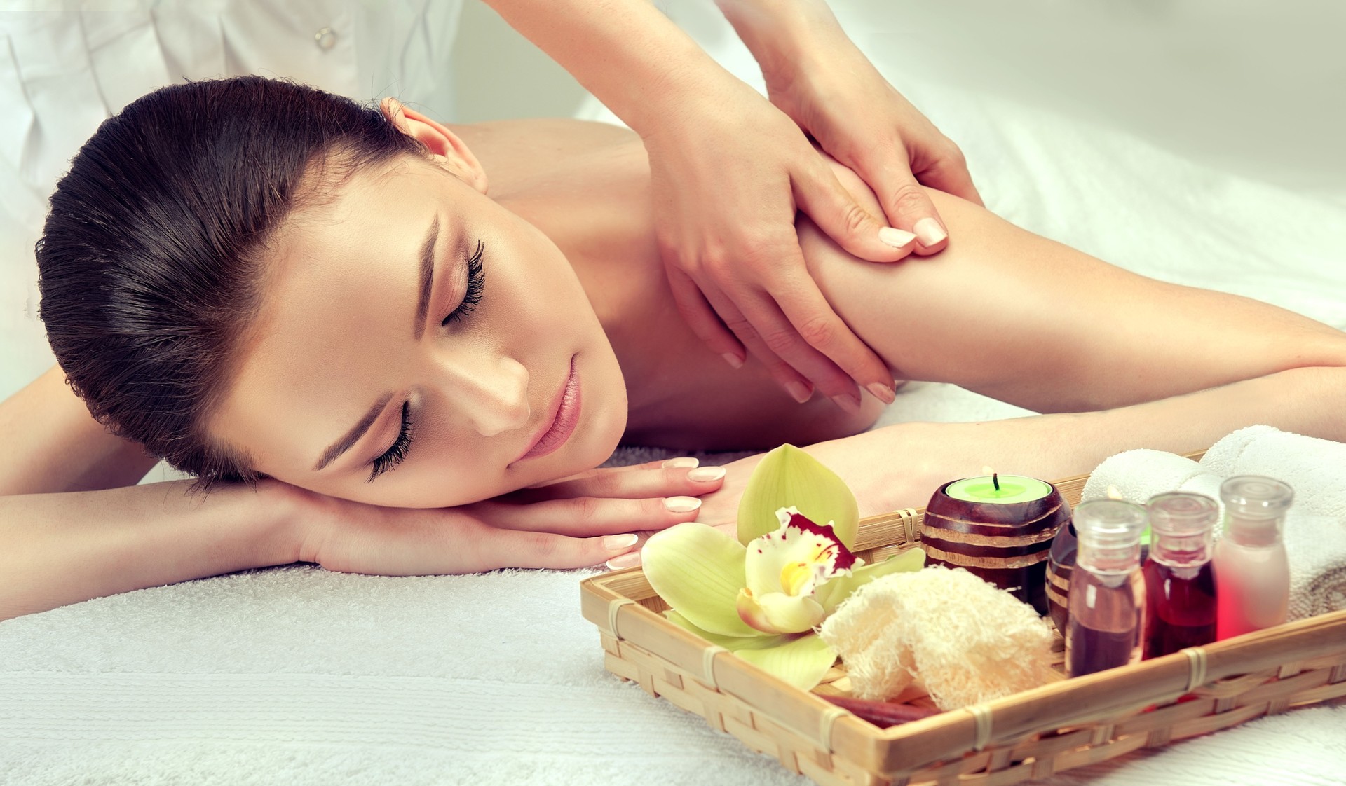 Mãos terna e suaves de massagem especialista está fazendo massagem nas costas da jovem mulher.